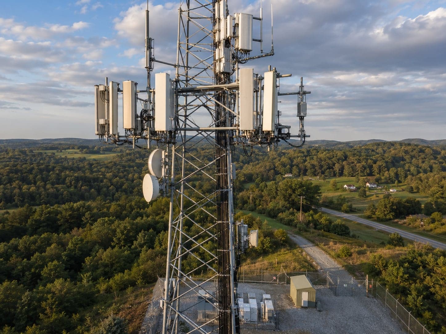 Aerial drone view of a steel lattice cell tower against open sky